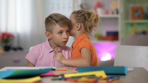 Χαριτωμένο κορίτσι ψιθυρίζοντας μυστικό αδελφός αυτί, γελά μαζί, κουτσομπολεύουν παιδικής ηλικίας — Αρχείο Βίντεο