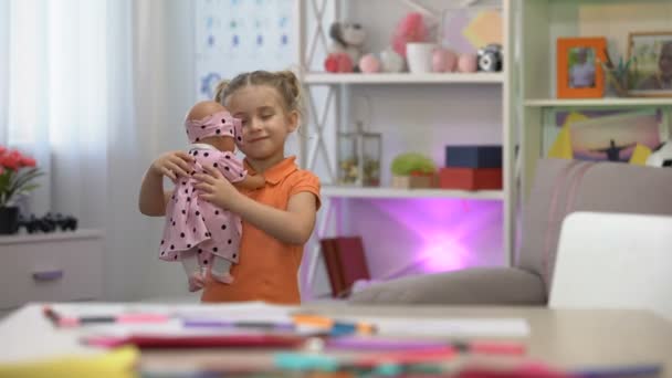 Mädchen hält Puppe, umarmt Lieblingsspielzeug, mädchenhafte Freizeit, Kinderglück — Stockvideo