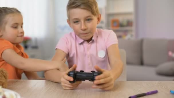 Liten flicka störande bror spelar konsolspel, barn kämpar joystick — Stockvideo