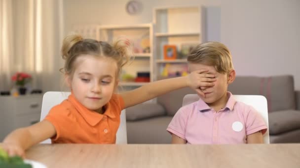 Irmãzinha Alimentando Irmão Com Brócolis Cobrindo Seus Olhos Brincando Amigo — Vídeo de Stock