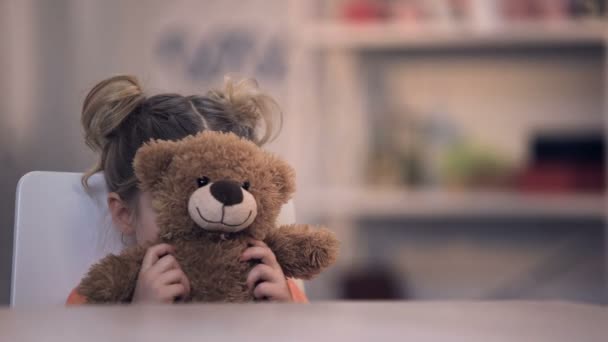 Triste niña cubriendo la cara por juguete de oso de peluche, problema familiar, abuso de soledad — Vídeos de Stock