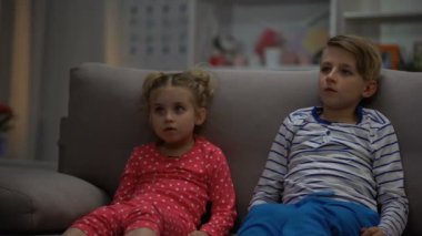 Küçük erkek ve kız gece, kanepeye, boş zaman oturma korku filmi izlerken