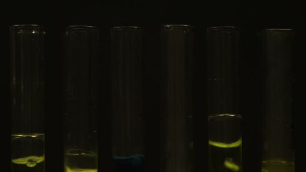 Liquids boiling in test tubes against black background, illegal laboratory — Stock Video