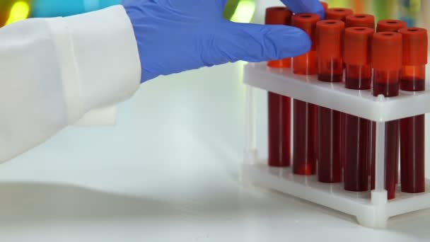 Laboratory scientist taking test tube with blood sample, biochemical test — Stock Video