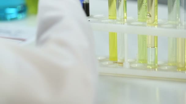 Investigador de laboratorio de cosmetología se prepara para mezclar extracto de carbón con producto cosmético — Vídeos de Stock