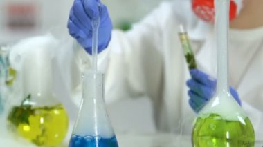 Araştırmalar yürüten kadın bilim adamı ekleme aracı test tüpü ile bitki, içine