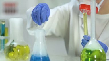 Farklı reaktifler, kimya karıştırma araştırmalar yürüten kadın laboratuar işçisi