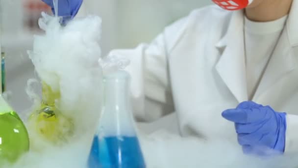 Kvinna från forskning lab att undersöka urval av vätska under kemisk reaktion — Stockvideo
