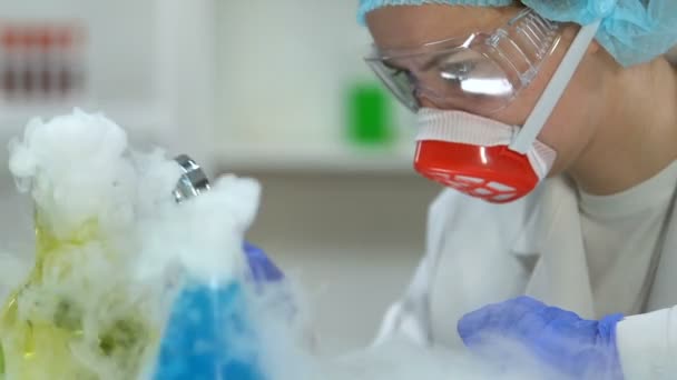 Woman scientist examining reaction of chemical liquids through magnifying glass — Stock Video