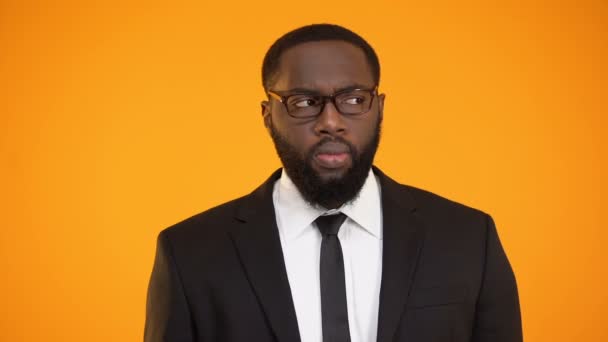 Озадаченный афро-американский бизнесмен рассматривает варианты, недостаточную информацию — стоковое видео