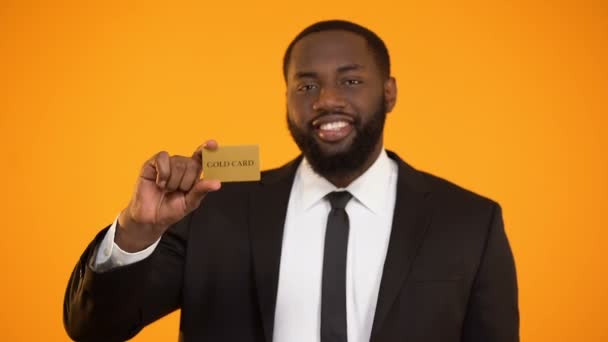 Smiling confident afro-american businessman showing gold card and ok gesture — Stock Video