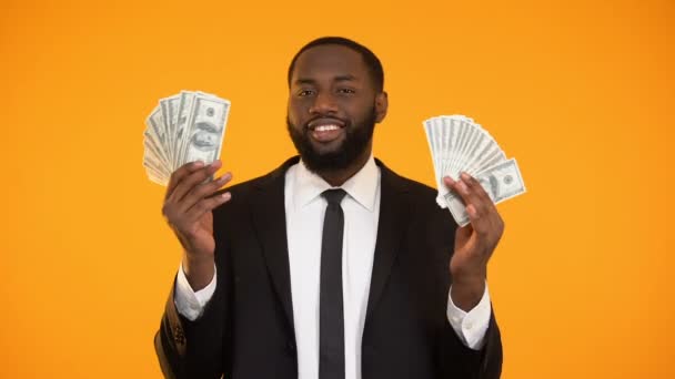 Sexy african-american male in suit playing with dollar banknotes and making kiss — Stock Video