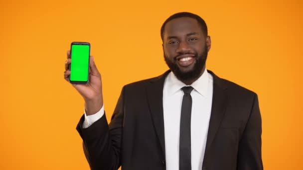 Gösterilen resmi kıyafeti içinde gülümseyen Afro-Amerikan adam telefon, reklam prekeyed — Stok video