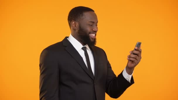 Successful afro-american businessman reading news on phone, making yes gesture — Stock Video
