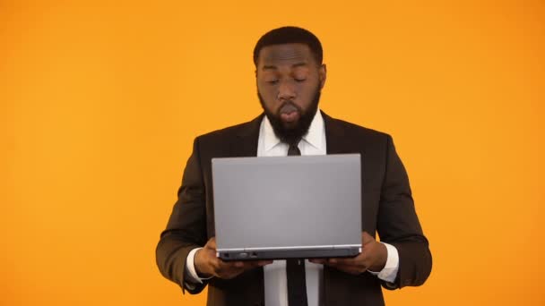 Verbaasd Afro-Amerikaanse man lezen van nieuws op laptop, carrière promotie, winnaar — Stockvideo