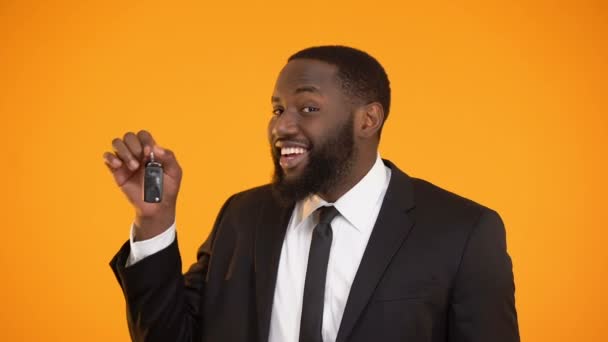 Smiling african-american male showing automobile keys, renting car, leasing — Stock Video