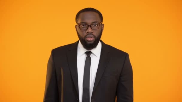 Αφρο-αμερικανικό άνθρωπος στο κοστούμι δείχνει ήσυχο σημείο, κουτσομπολιά, αποκάλυψη προσωπικών δεδομένων — Αρχείο Βίντεο