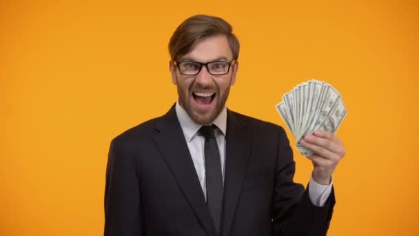 Geschäftsmann zeigt Dollar-Banknoten und tut ja Geste, hohes Gehalt, Einkommen — Stockvideo
