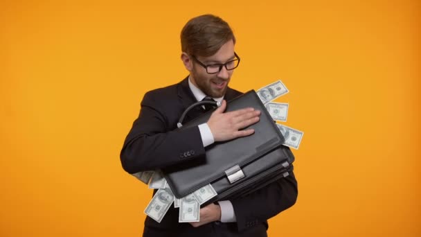 Businessman hugging briefcase full of money, isolated on yellow background — Stock Video