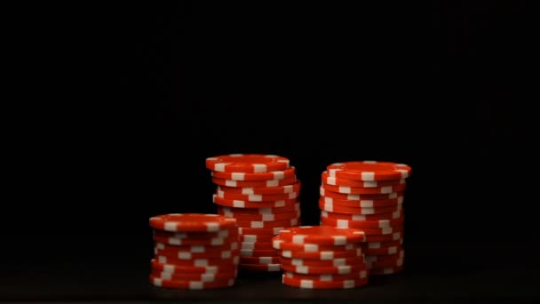 Hand zetten rode chips geïsoleerd op zwart, gokverslaving, casino bedrijf — Stockvideo