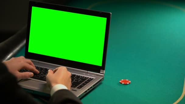 Man met behulp van wedden onlineservices op laptop, het houden van lucky chip, groen scherm — Stockvideo