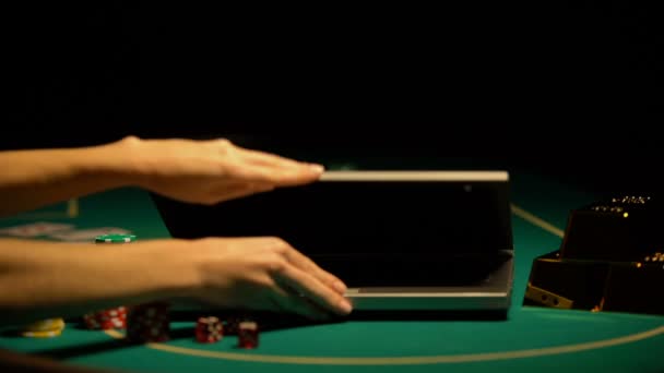 Mãos abrindo laptop, fichas de poker e riqueza ao redor, tentação de ganhar jackpot — Vídeo de Stock