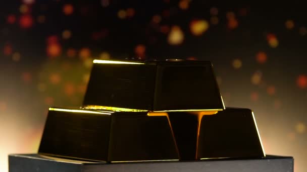 Сияющие золотые слитки, разворачивающиеся на пьедестале на размытом фоне — стоковое видео