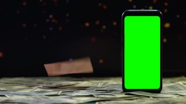 Carte da gioco che cadono sulla scrivania con contante e schermo verde smartphone, vincite — Video Stock
