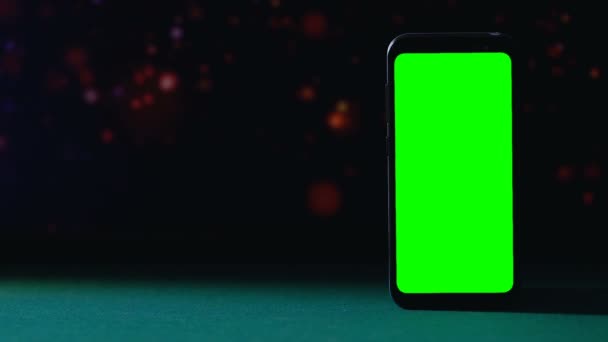 Smartphone de pantalla verde de pie sobre fondo oscuro, aplicación de casino — Vídeos de Stock