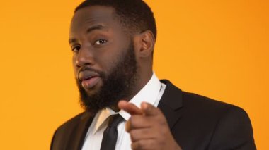 Afrikalı-Amerikalı adam gösterilen işareti ararsın ve kameraya, göz kırpıyor banka hizmetleri