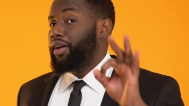 Afrikalı-Amerikalı adam ok jest, karlı yatırım projesi gösterilen takım elbiseli