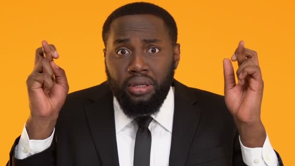 Bezorgd zwarte man in pak kruising vingers voor goed geluk voor sollicitatiegesprek — Stockvideo