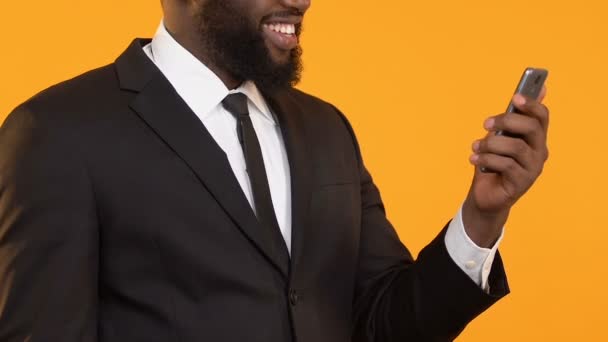 はいジェスチャー、ビジネス用の電子メールを示すスマート フォンを保持しているスーツのうれしい黒男 — ストック動画