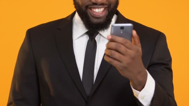 Ευτυχισμένος Αφροαμερικάνικης αρσενικό σε κοστούμι κρατώντας smartphone δείχνει Ναι χειρονομία, κλήρωση — Αρχείο Βίντεο