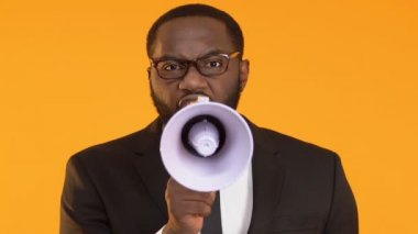 Kızgın Afrikalı-Amerikalı patron çalışanlara bağırmak için megafon kullanarak takım elbiseli