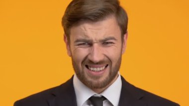 Adam acı korkunç baş ağrısı, izole üzerinde turuncu arka plana, yakın çekim