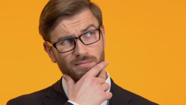 Thoughtful man scratching his chin, trying to make decision, bright background — Stock Video