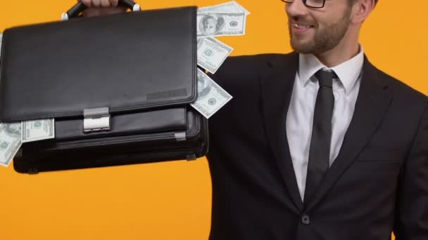 Χαμογελαστός άνθρωπος δείχνει αντίχειρας-επάνω κρατώντας πλήρη χαρτοφύλακα του χρήματος, εκκίνηση κέρδη — Αρχείο Βίντεο