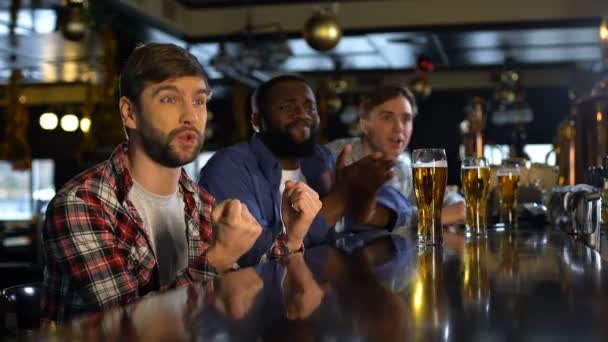 Amigos masculinos animando por el juego de deportes, emocionados con la victoria de la selección nacional — Vídeo de stock