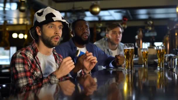 Football fans watching match in pub, frustrated with missed goal, losing game — Stock Video