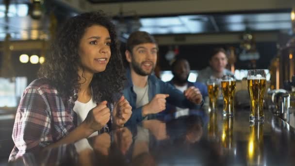 Biracial Mädchen mit Freunden beobachten Sportspiel in der Bar, glückliche Zeit zusammen — Stockvideo