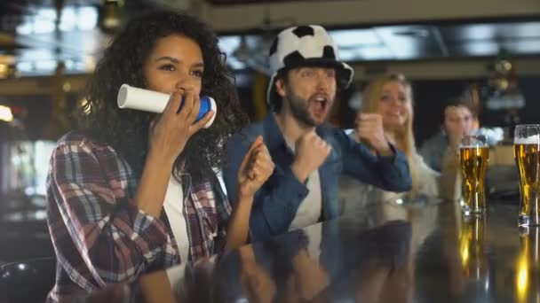 Amantes del fútbol masculino y femenino apoyando a la selección nacional en el pub, disfrutando de la victoria — Vídeo de stock