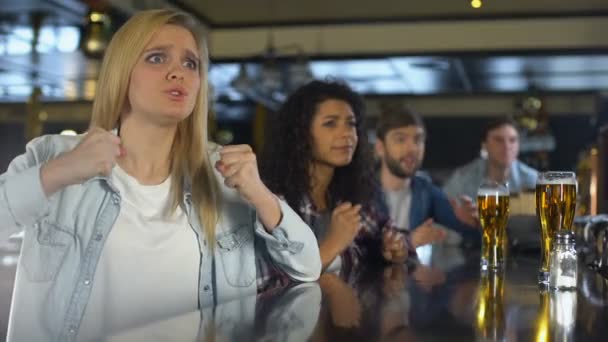 Mooie blonde met vrienden kijken naar sport in pub boos over het verliezen van spel — Stockvideo