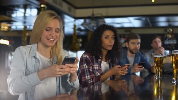 Молодые люди в баре празднуют победу в спортивных ставках, букмекер мобильное приложение — стоковое видео