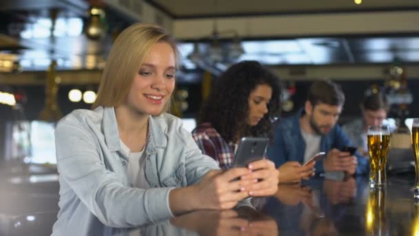 Los jóvenes que usan teléfonos celulares en el bar, la lectura de mensajes en citas aplicación, wi-fi gratis — Vídeos de Stock