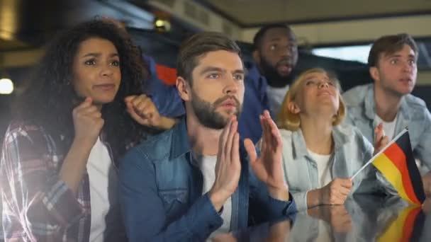 Fãs acenando bandeira alemã, assistindo programa de esportes no bar, chateado com a perda de jogo — Vídeo de Stock