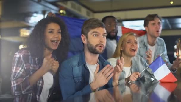 I fan sventolano la bandiera francese, guardano il programma sportivo nel bar, sconvolti per aver perso la partita — Video Stock
