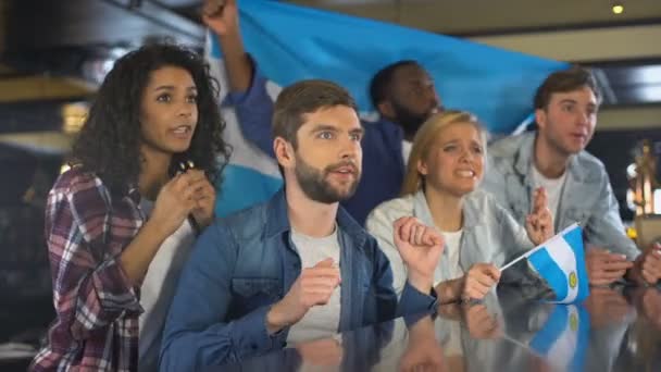 Aficionados al deporte multirracial ondeando bandera argentina, molestos por perder el juego, derrota — Vídeos de Stock