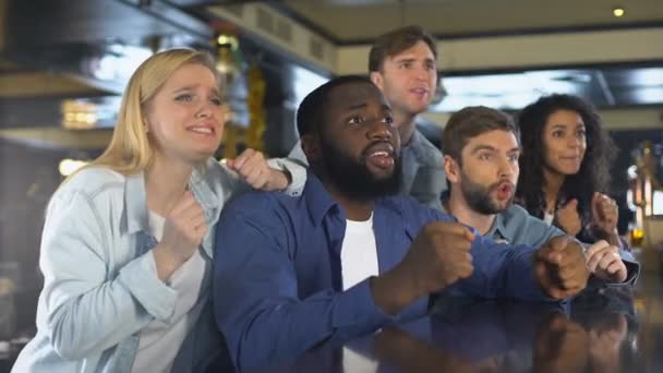 Vänner tittar på sport tillsammans i bar, upprörd över att förlora spel, besviken — Stockvideo