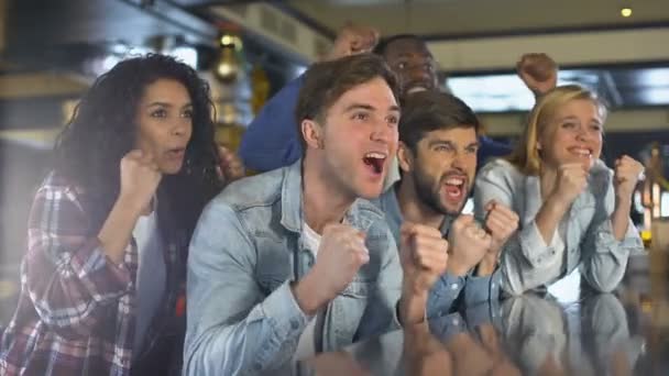 Amici multirazziali che sostengono la squadra guardando la partita insieme, battendo le mani — Video Stock